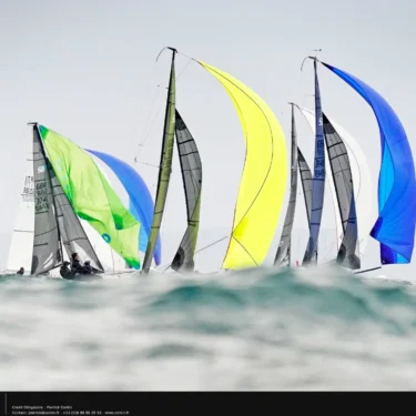 SB20s racing downwind under colourful gennakers at Hyères