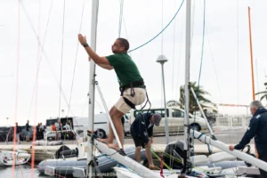 Sailor climbing an SB20 mast in the Hyères marina