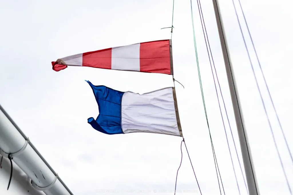 Postponement flag flying above the French flag in the Hyères marina on Day 1 of the SB20 World Championship