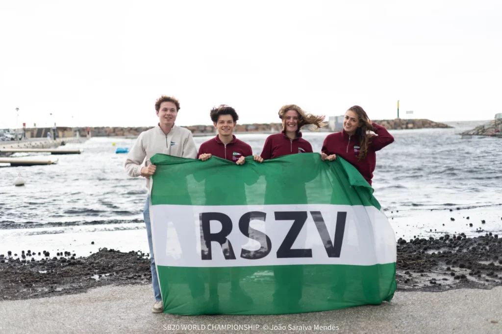Dutch student team holding their RSZV flag on the beach in Hyères