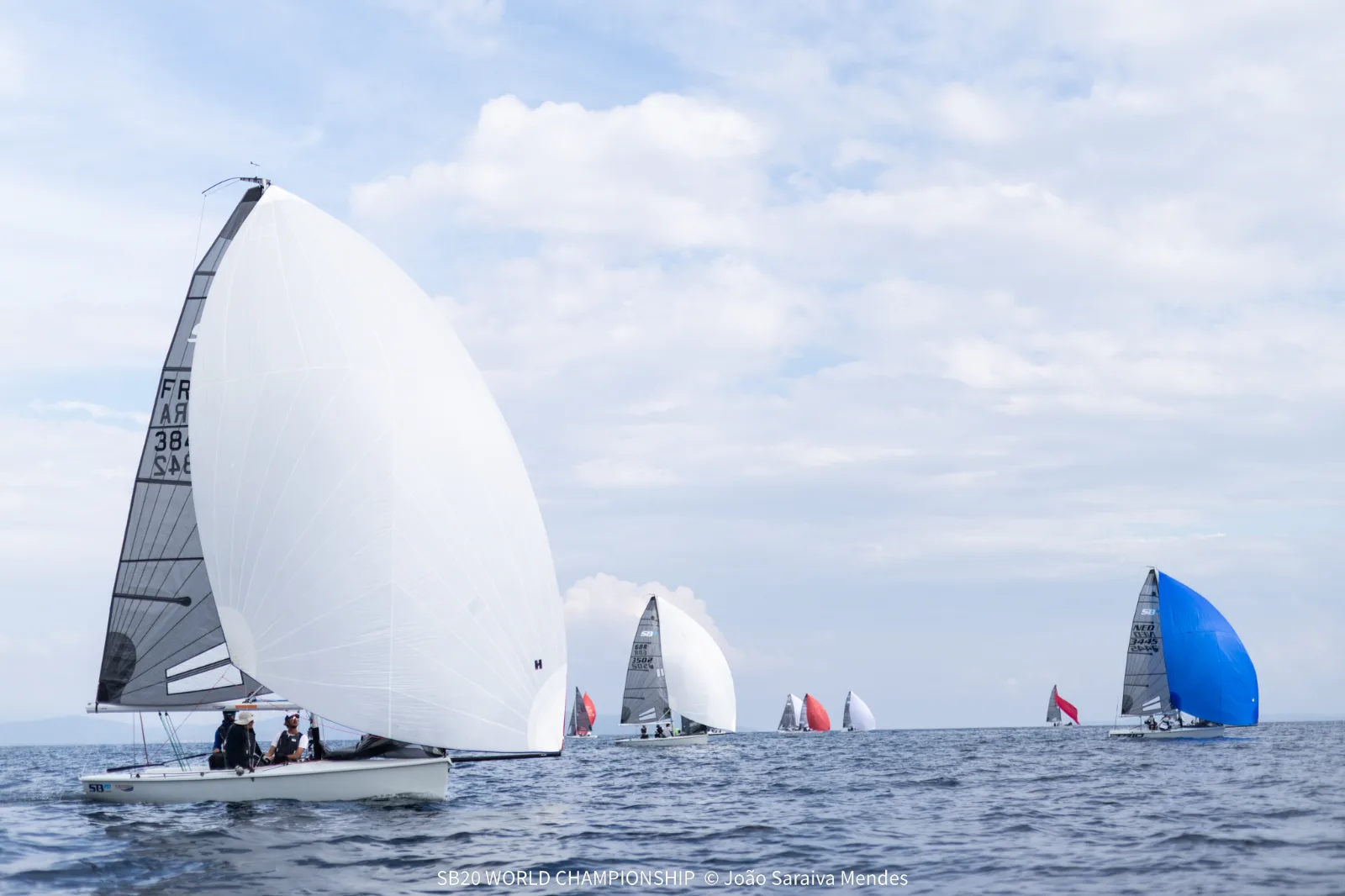 SB20 sailing downwind under a white gennaker with the fleet behind on the practice day of the SB20 World Championship in Hyères